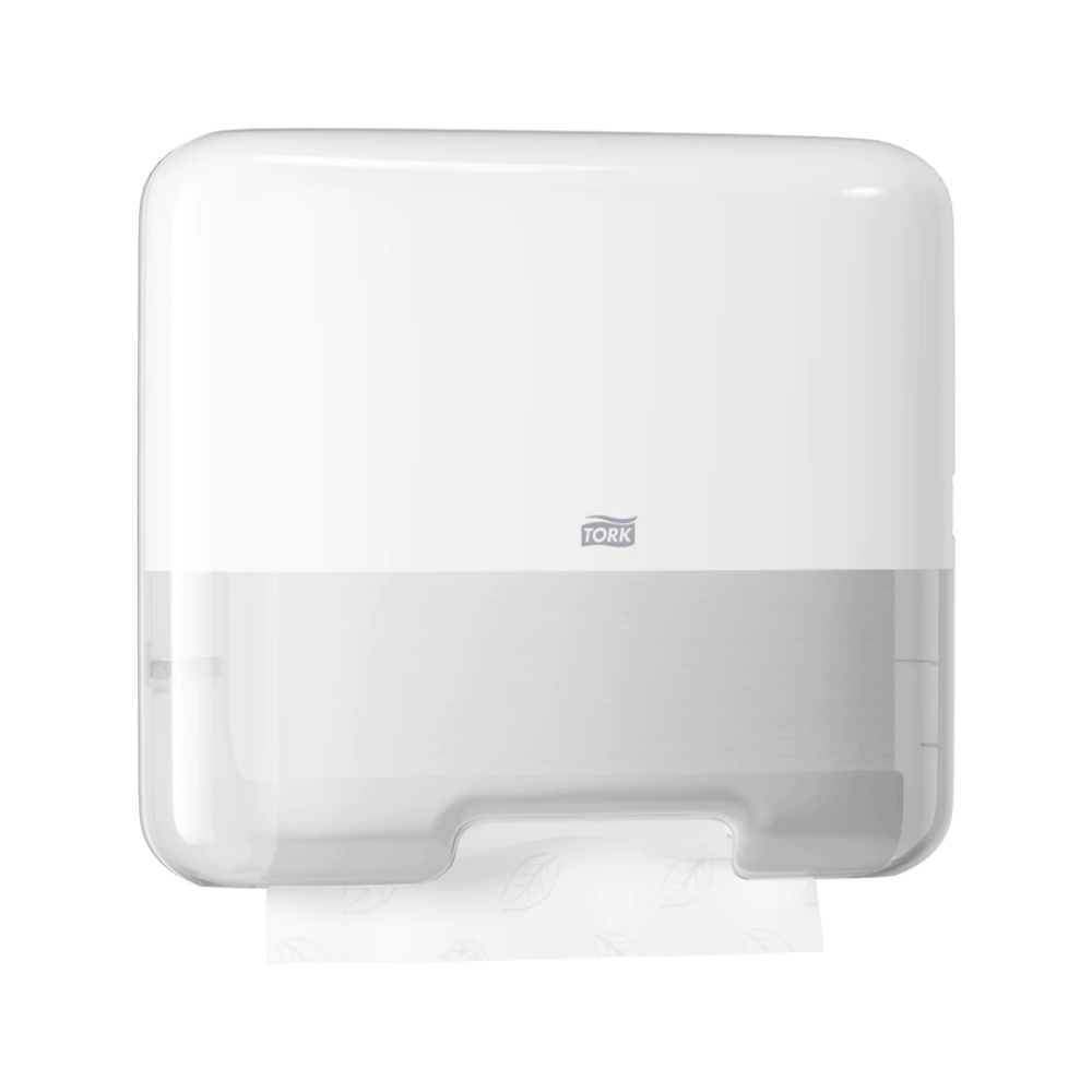Mini dávkovač Tork 553100 pro skládané ručníky, navržený v moderním stylu Elevation H3, elegantně prezentuje značku „Tork“ na přední straně. Průhledná oblast ve spodní části umožňuje pohled na částečně vydaný skládaný ručník.