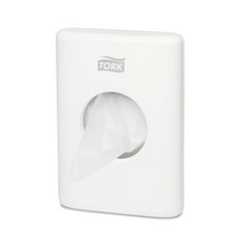 Ein Tork 566000 Hygienebeutelspender Elevation B5, der für die Wandmontage konzipiert ist, präsentiert elegant die Marke „TORK – Essity Professional Hygiene Germany GmbH“ an der Oberseite. Ein Beutel wird teilweise aus der zentralen Öffnung herausgezogen, was sowohl Komfort als auch Stil in Ihrem Raum erhöht.