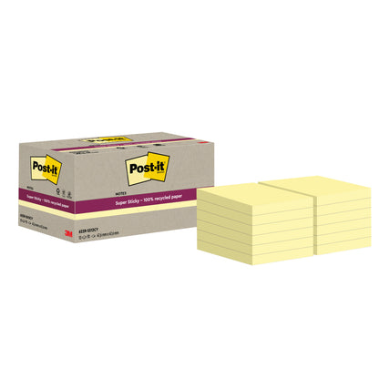 Krabice s nápisem "Post-it® Super Sticky 100% recyklované poznámky, 47,6 mm x 47,6 mm, 70 listů/blok, 100% PEFC" od 3M Deutschland GmbH stojí vedle několika hromádek žlutých čtvercových poznámek.