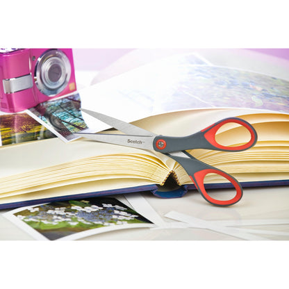 Die Scotch™ Präzisionsschere rot von 3M Deutschland GmbH liegt auf einem geöffneten Fotoalbum mit Fotos. Auf dem Tisch sind auch eine rosa Kamera und lose Fotos zu sehen.