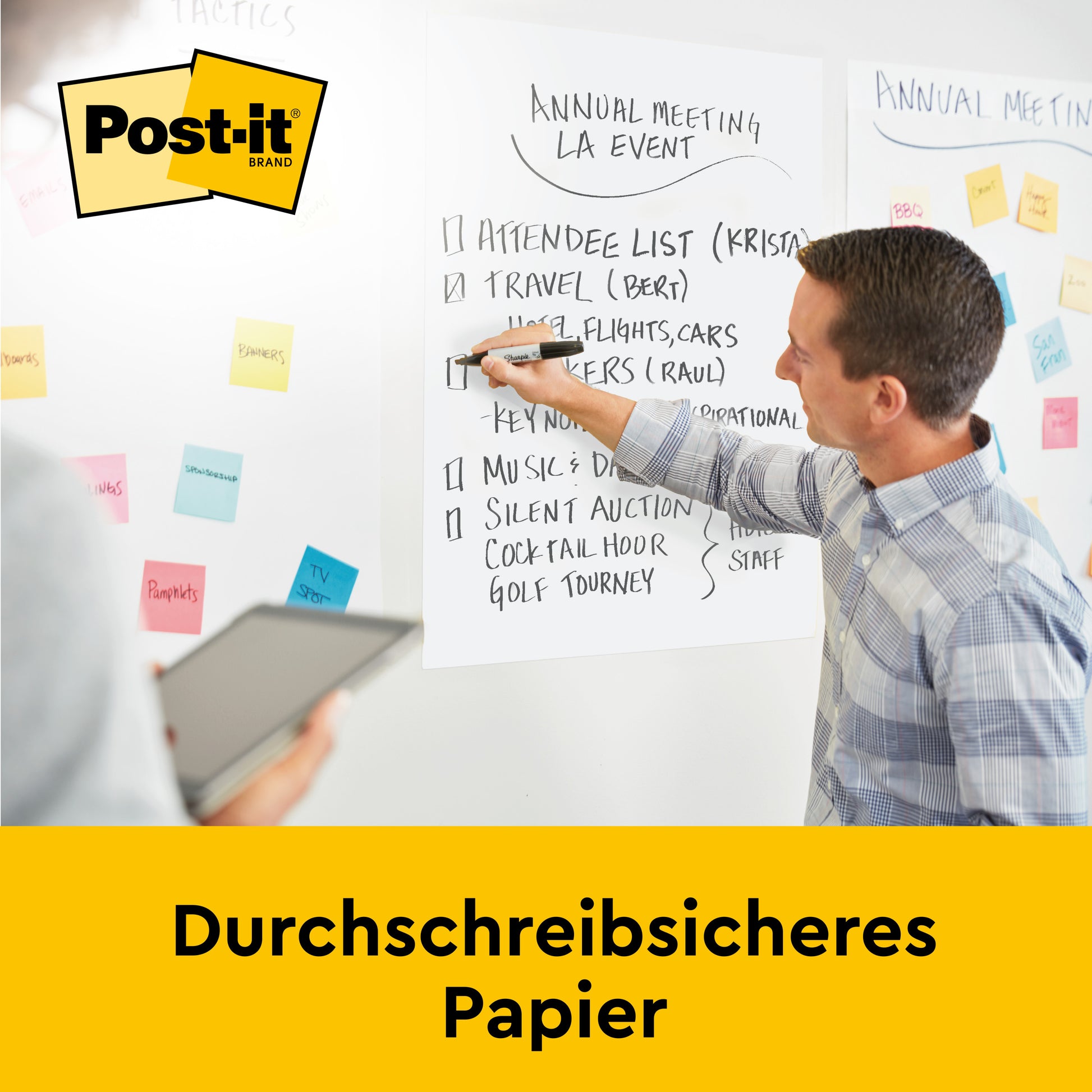 Während eines Meetings schreibt ein Mann auf einer Post-it® Super Sticky Recycling Meeting Chart der 3M Deutschland GmbH, während eine andere Person mit einem Tablet beobachtet; Haftnotizen sind sichtbar und "Durchschreibsicheres Papier" ist auf einem gelben Banner zu sehen.
