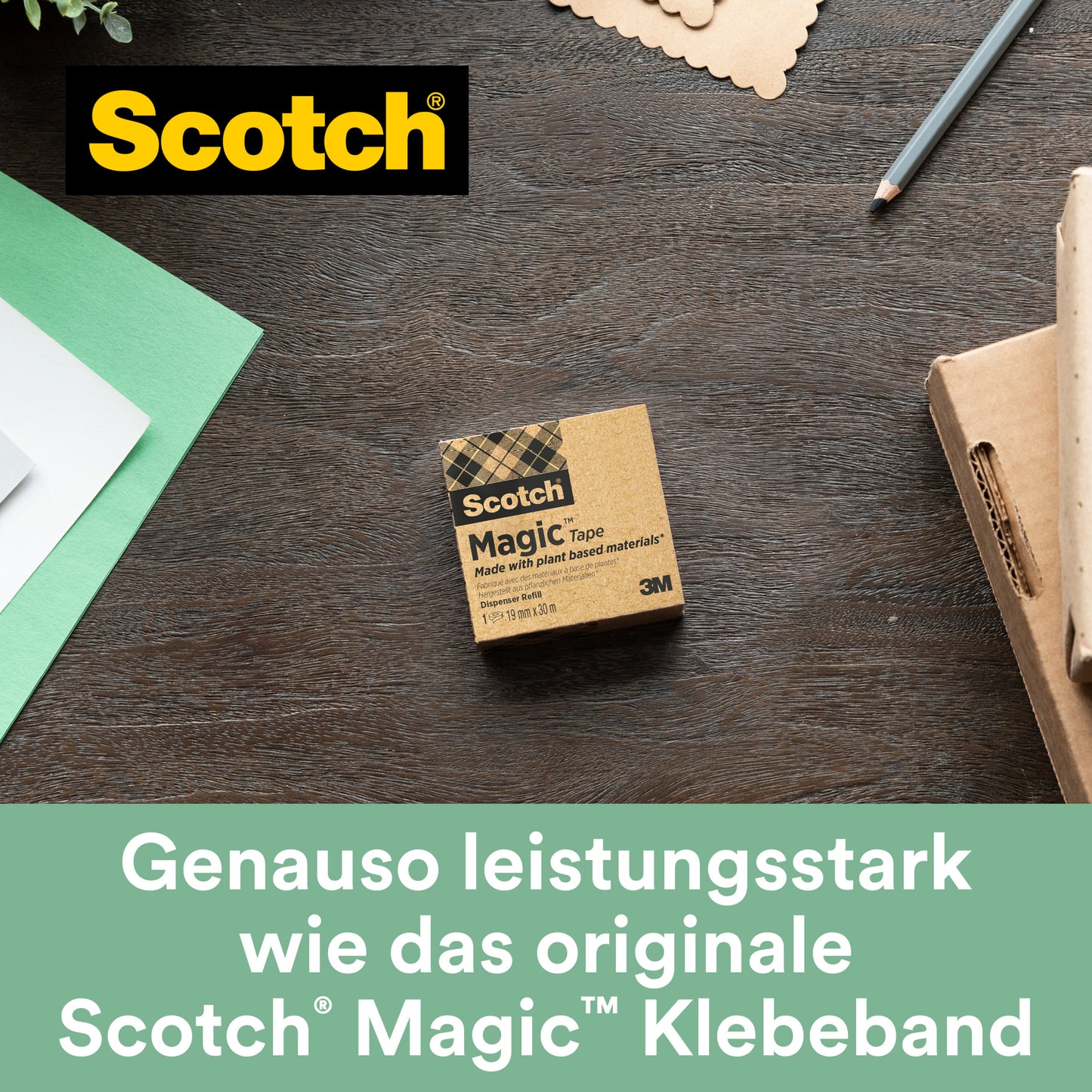 Černý stolní dávkovač Scotch® C38 s 3 rolemi pásky Scotch® Magic™ (19 mm x 33 m, 66 % rostlinné lepidlo) od 3M Deutschland GmbH leží na dřevěném povrchu vedle papíru, pera a kartonu.