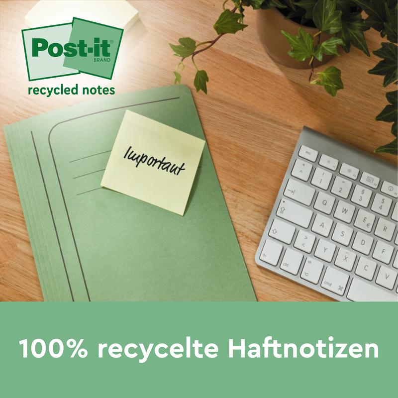 Zelený pořadač s žlutým Post-it® Recycling Z-Zettel (3M Deutschland GmbH, 76x76mm, 100% PEFC) s nápisem "důležité" leží na dřevěném stole vedle klávesnice a rostliny. Na obrázku je napsáno: "100% recyklované samolepicí poznámky" a "recyklované poznámky".