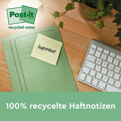 Zelený pořadač s žlutým Post-it® Recycling Z-Zettel (3M Deutschland GmbH, 76x76mm, 100% PEFC) s nápisem "důležité" leží na dřevěném stole vedle klávesnice a rostliny. Na obrázku je napsáno: "100% recyklované samolepicí poznámky" a "recyklované poznámky".