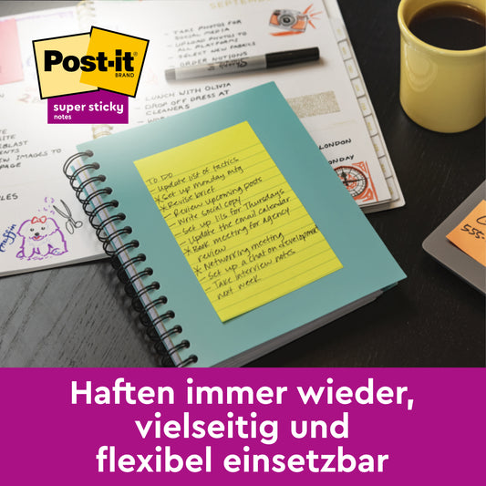Eine gelbe Post-it® Super Sticky Meeting Note (203 x 153 mm) von 3M Deutschland GmbH ist an einem tealfarbenen Notizbuch auf einem Schreibtisch mit Papieren, einer Kaffeetasse und bunten Stiften befestigt. Am unteren Rand wirbt Text auf Deutsch für die Vielseitigkeit der Notizen.