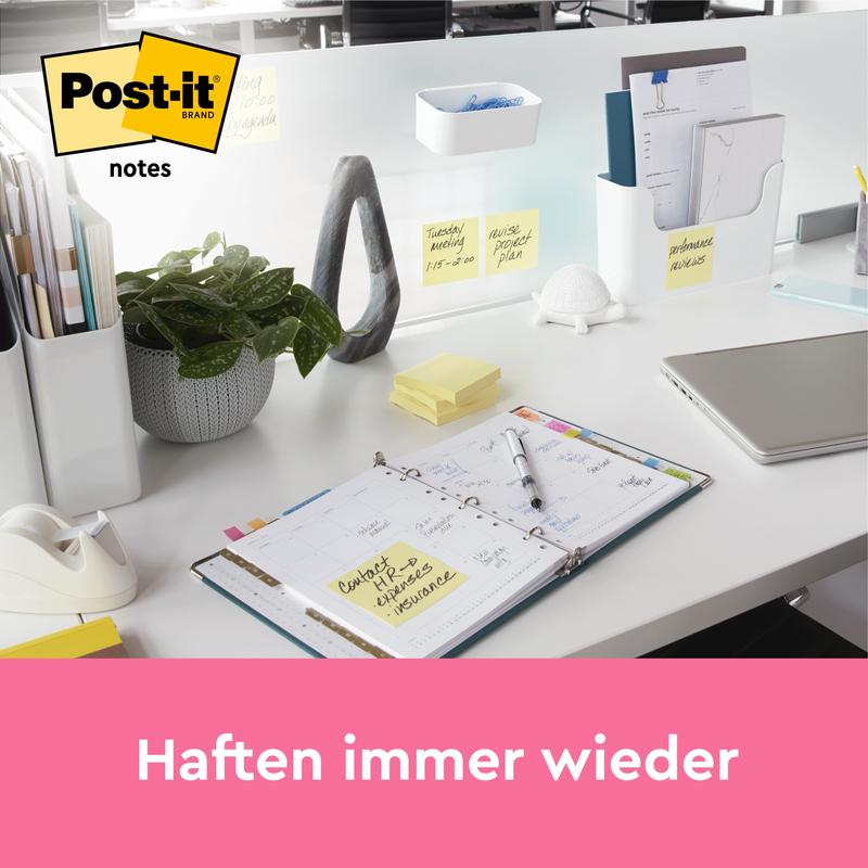Uklizený kancelářský stůl ukazuje poznámkové bloky Post-it® Notes, Žlutá, 38 mm × 51 mm (100 listů/blok, 12 bloků/balení, 100% PEFC) od 3M Deutschland GmbH. Poznámky jsou viditelné na stole a přepážce. Text pod nimi zní: "Přilnou znovu a znovu."
